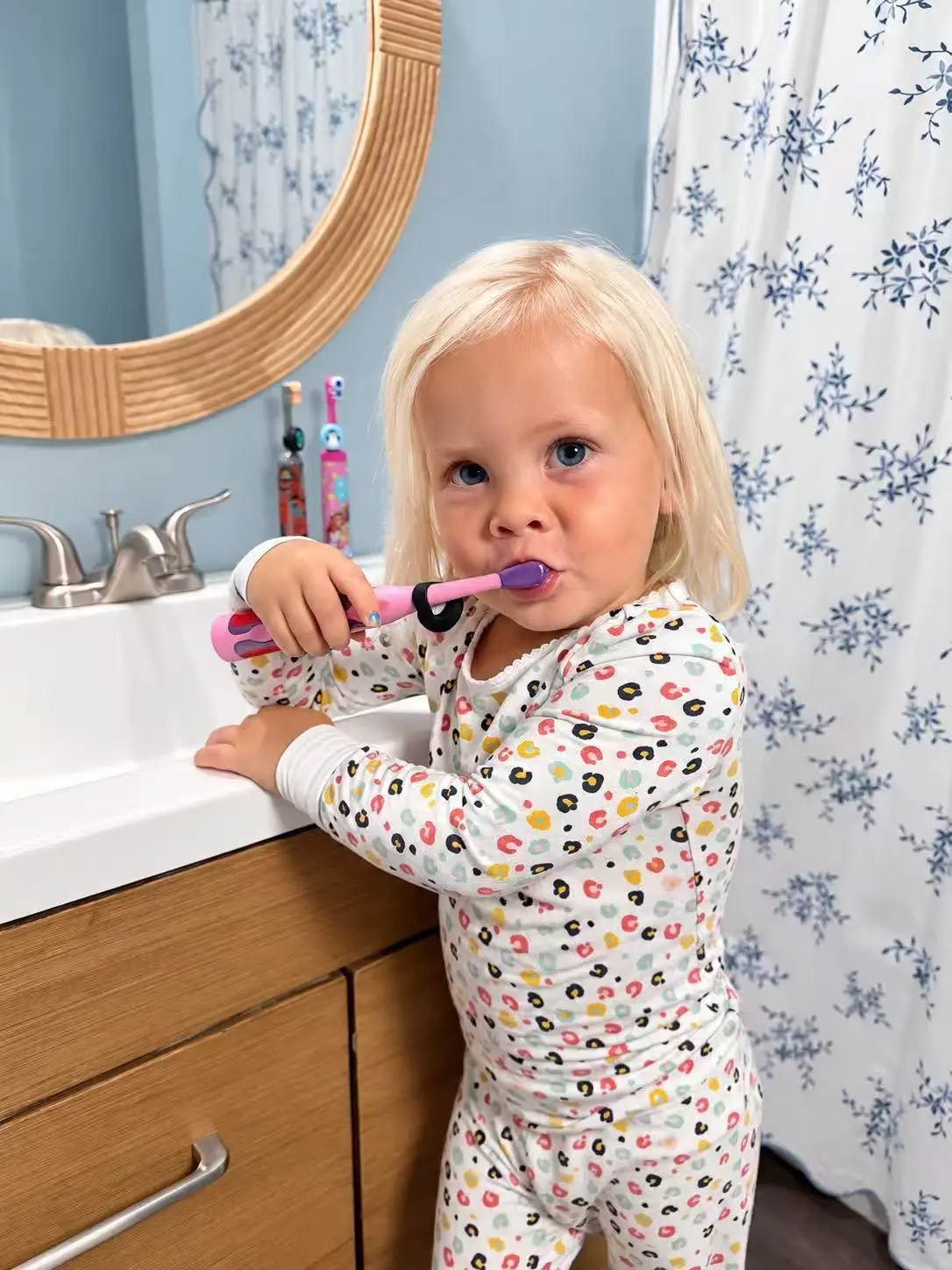 Toddler brushing her teeth with a Truthbrush Tracker clipped to her toothbrush