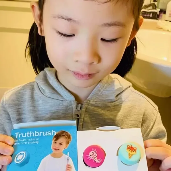 Girl unboxing a Truthbrush Classic Tracker with a tray of tracker skins