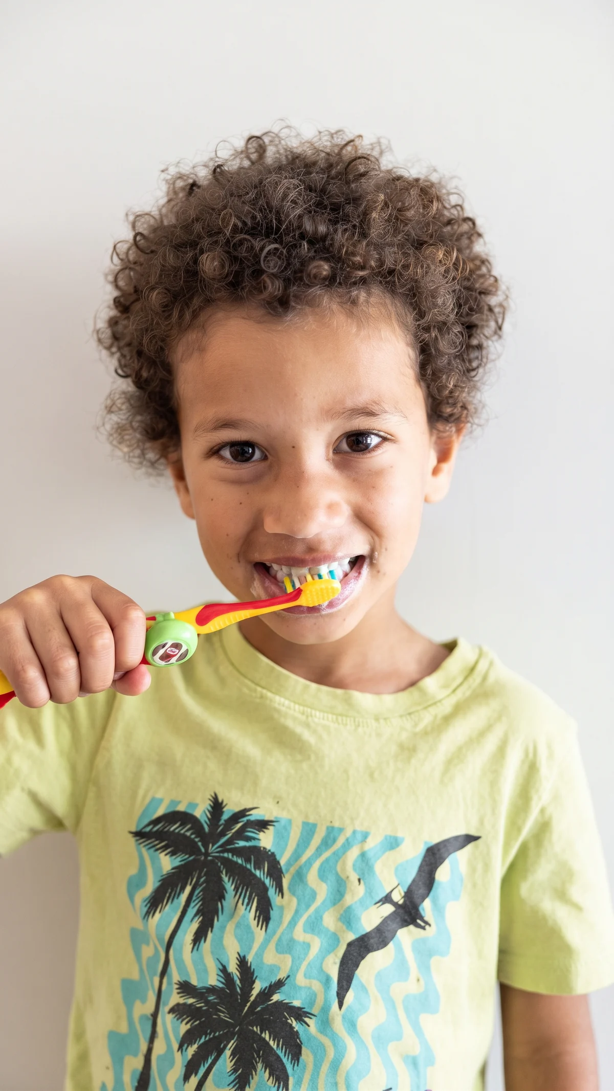 Boy brushing his teeth with a Truthbrush Tracker clipped to his toothbrush