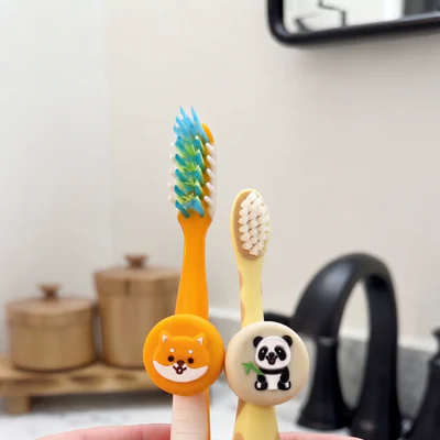 Two children's toothbrushes fitted with fox and panda Truthbrush Tracker skins