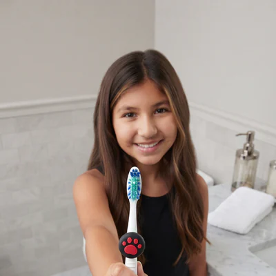 Older child holding out a toothbrush with a paw-print Truthbrush Tracker